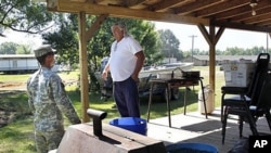 A member of the Louisiana National Guard talks to a resident who did not want to be identified, as they reinforce the town in preparation for expected flooding from the opening of the Morganza Spillway, in Krotz Springs, Louisiana, May 17, 2011