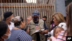 Robert Vivar of the Unified U.S. Deported Veterans Resource Center talks with migrants as they wait to cross into the United States to begin the asylum process July 5, 2021, in Tijuana, Mexico.