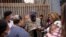 Robert Vivar of the Unified U.S. Deported Veterans Resource Center talks with migrants as they wait to cross into the United States to begin the asylum process July 5, 2021, in Tijuana, Mexico.