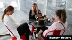 Customers sit at a restaurant on the first day of eased New South Wales coronavirus disease (COVID-19) restrictions, allowing up to 10 patrons to sit at a time inside establishments previously only open for take-away, in Sydney, Australia, May 15, 2020.