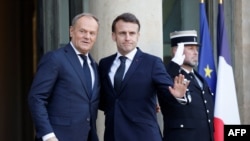 O Presidente francês Emmanuel Macron (direita) e o Primeiro-Ministro polaco Donald Tusk (esquerda)