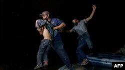 Migrantes de Centroamérica que cruzan ilegalmente de México a Estados Unidos para buscar asilo desembarcan de un bote inflable en el lado estadounidense del río Grande en la ciudad fronteriza de Roma, el 29 de marzo de 2021.