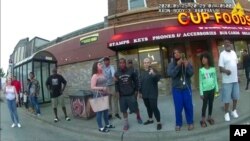 FILE - This May 25, 2020, image from a police body camera shows bystanders including Darnella Frazier, third from right, recording, as former Minneapolis police Officer Derek Chauvin pressed his knee on George Floyd's neck.