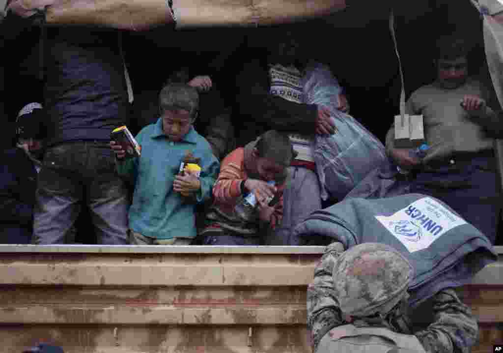 Newly-arrived Syrian refugees ride a Jordanian military vehicle after crossing into Ruweishid, Jordan, Dec. 5, 2013. 