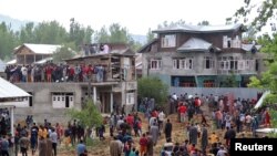 People gather after several militants, including Hizbul Mujahideen commander Riyaz Naikoo were killed in a gun battle with Indian soldiers, at Beighpora village in south Kashmir's Pulwama district, May 6, 2020. 