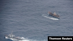 Buques de la Armada ecuatoriana rodean un barco pesquero luego de detectar una flota pesquera de barcos en su mayoría con bandera china en un corredor internacional que limita con la zona económica exclusiva de las Islas Galápagos, en el Océano Pacífico.