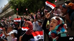 Yemeni children chant slogans and wave Yemeni flags that read "Yemen one" in Arabic, during a protest in Sana'a against Saudi-led airstrikes in Yemen, June 6, 2015.