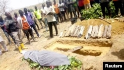People attend the burial of Monday Doma, the student killed after gunmen stormed the Government Science Secondary School Kagara and kidnapped dozens, in Niger state, Nigeria, Feb. 17, 2021.