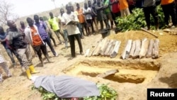 People attend the burial of Monday Doma, the student killed after gunmen stormed the Government Science Secondary School Kagara and kidnapped dozens, in Niger state, Nigeria, Feb. 17, 2021.