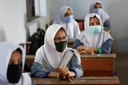FILE - Students keep safe distance while attending a class as schools reopen amid the coronavirus disease (COVID-19) pandemic, in Karachi.