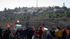 FILE - Palestinians protest against expected visit of the U.S. Secretary of State Mike Pompeo to the Jewish settlement of Psagot near the West Bank city of Al-Bireh, Nov. 18, 2020.