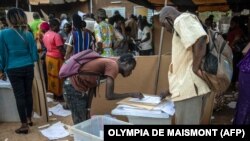 Anggota TPS memeriksa materi pemilu di balai kota tempat Komisi Pemilihan Nasional Independen (CENI) di Ouagadougou, pada 21 November 2020 di Burkina Faso, 21 November 2020. (Foto: AFP)