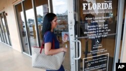 A woman enters a Florida Highway Safety and Motor Vehicles drivers license service center, Oct. 8, 2019, in Hialeah, Fla.