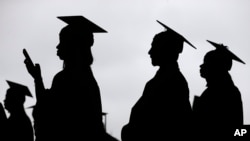 FILE - New graduates line up before the start of the Bergen Community College commencement at MetLife Stadium in East Rutherford, N.J, May 17, 2018. 