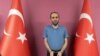 Selahaddin Gulen, a nephew of U.S.-based Muslim cleric Fethullah Gulen, stands between Turkish flags in this photo provided by the Turkish intelligence service, in Ankara, Turkey, May 31, 2021. 