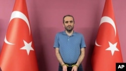 Selahaddin Gulen, a nephew of U.S.-based Muslim cleric Fethullah Gulen, stands between Turkish flags in this photo provided by the Turkish intelligence service, in Ankara, Turkey, May 31, 2021. 