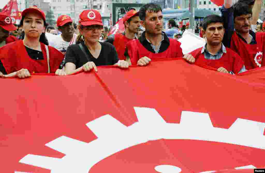 Para anggota serikat dagang meneriakkan slogan-slogan anti Perdana Menteri Recep Tayyip Erdogan saat berpawai di Alun-Alun Taksim di Istanbul (5/6). (Reuters/Yannis Behrakis)