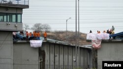 Los reclusos de la cárcel Regional de Guayaquil sostienen pancartas que dicen "Queremos la paz", "La ley nos está matando", "Paz, no a la violencia", luego de que se reportaran disturbios en el Penitenciaria del Litoral. Octubre 2, 2021.