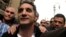Bassem Youssef (C), the country's best-known satirist, gestures to journalists and activists as he arrives at the high court to appear at the prosecutor's office in Cairo Mar. 31, 2013.