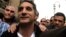 Bassem Youssef (C), the country's best-known satirist, gestures to journalists and activists as he arrives at the high court to appear at the prosecutor's office in Cairo Mar. 31, 2013.