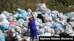 Une femme trie les matériaux recyclables dans un dépôt de recyclage du parc Linbro, Johannesburg, Afrique du Sud, le 18 mars 2021. (REUTERS/Siphiwe Sibeko)