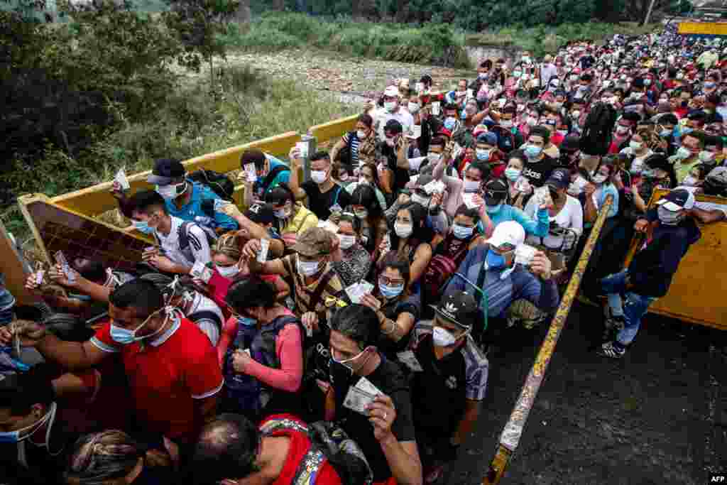 People coming from Venezuela with protective face masks as a precautionary measure to avoid contracting the new coronavirus, COVID-19, show hold their documents on the border at Simon Bolivar International Bridge, in Cucuta, Colombia.