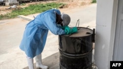 A hygienist rests as he waits outside a decontamination area in a COVID-19 coronavirus treatment center that cares for positive patients who show little or no symptoms, in Dakar, Senegal.