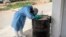 A hygienist rests as he waits outside a decontamination area in a COVID-19 coronavirus treatment center that cares for positive patients who show little or no symptoms, in Dakar, Senegal.