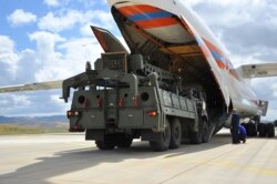 Military vehicles and equipment, parts of the S-400 air defense systems, are unloaded from a Russian transport aircraft, at Murted military airport in Ankara, Turkey, July 12, 2019.