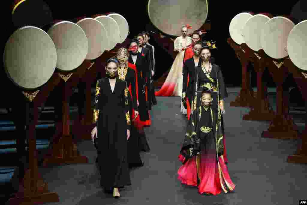 Models display creations from the &quot;Heaven Gaia&quot; collection by Xiong Ying during the China Fashion Week in Beijing.