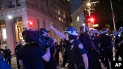 FILE - A police officer shouts at a video journalist in New York City, June 2, 2020, during demonstrations protesting the death in Minneapolis police custody of George Floyd.