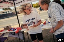 FILE— Cape Independence Party (CapeXit) volunteers and agents hand out flyers and campaigning material at a party campaign point in Cape Town on March 2, 2024.