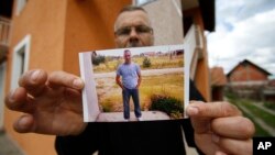 Bosnian Andjelko Djuric, 45, shows photos of his late brother Dragan Djuric, a police officer who was killed in Monday's attack at a police station in the eastern Bosnian town of Zvornik, 200 kilometers (124 miles) east of Sarajevo, April 28, 2015.