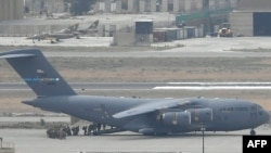 30일 아프가니스탄 카불 국제공항에서 철수하는 미군 병력이 미 공군 수송기에 오르고 있다.
