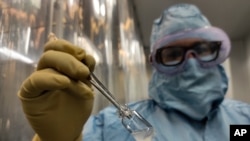 A technician shows a vial of the Cuban made COVID-19 vaccine called “Soberana 02” at the packaging processing plant of the Finlay Vaccine Institute in Havana, Cuba, Wednesday, Jan. 20, 2021. The director of the Finlay Institute said that Cuba hopes…