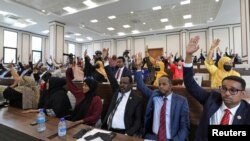 Somali legislators of the lower house of parliament raise their hands to vote to extend President Mohamed Abdullahi Mohamed's term for another two years, in Mogadishu, April 12, 2021.