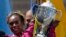 Rita Jeptoo of Kenya hoists the trophy after winning the women's division of the 118th Boston Marathon, April 21, 2014.