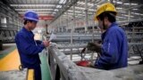 FILE - workers look over building beams at the Broad Sustainable Building Co. in Yueyang in central China's Hunan Province.