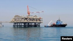 FILE - A ship is docked at a Al-Basra oil platform in the Middle East Gulf, Sept. 2014. 