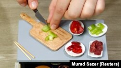 Juru masak makanan mini Burcu Celenoglu Aydin menyiapkan hidangan di dapur mininya di Istanbul, Turki, 7 April 2018. (Foto: REUTERS/Murad Sezer)