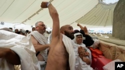 Jemaah haji melemparkan jumroh sebagai simbolis melempar setan, ritual terakhir haji tahunan, di Mina, dekat kota suci Mekah, Arab Saudi, Minggu, 16 Juni 2024. (Foto: AP)