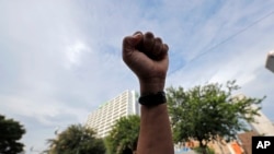 A demonstrator raises a fist in the air during a peaceful march in downtown New Orleans, June 2, 2020.