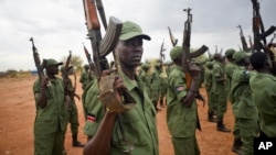 FILE - South Sudanese rebel soldiers raise their weapons at a military camp in the capital Juba, South Sudan.