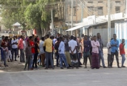 Somali people gather on the street during fighting between Somali government forces and opposition troops over delayed elections in Mogadishu, Somalia, Feb. 19, 2021.