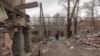 A woman walks past debris and damaged buildings after shelling in Kostyantynivka, in the eastern Donetsk region, on Feb. 7, 2025, amid the Russian invasion of Ukraine. 