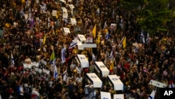 Sejumlah demonstran membawa peti mati tiruan yang diselimuti oleh bendera Israel dalam aksi demo di Tel Aviv, Israel, pada 5 September 2024. (Foto: AP/Ohad Zwigenberg)