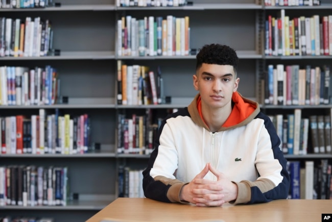 Max Decker, a senior at Lincoln High School, sits for a portrait in the school library where he often worked on writing his college essays, in Portland, Ore., Wednesday, March 20, 2024. (AP Photo/Amanda Loman)