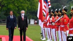 PM Malaysia Ismail Sabri Yaakob (tengah) dan Presiden Indonesia Joko Widodo (kiri) memeriksa barisan pasukan pengawal kehormatan dalam pertemuan di Bogor, Jawa Barat, Rabu, 10 November 2021. (Istana Kepresidenan RI via AP)