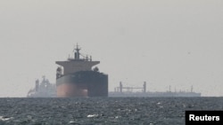 资料照片：美国与以色列与伊朗发生冲突之际，从与阿曼穆桑达姆行政区接壤的拉斯海马北部眺望，可见霍尔木兹海峡附近的波斯湾上航行的货轮。(2026年3月11日)
