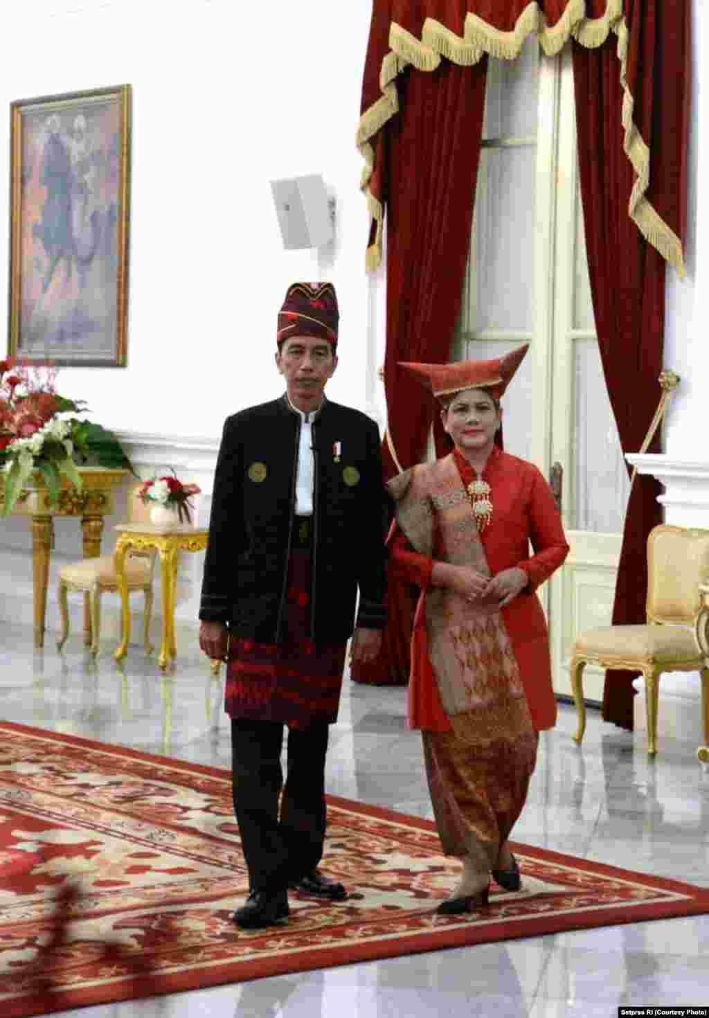 Presiden Jokowi yang mengenakan pakaian tradisional Tanah Bumbu Kalimantan Selatan, dan Ibu Negara Iriana mengenakan pakaian Minang Sumatera Barat, siap memimpin upacara bendera dan menyambut tamu di Istana Merdeka Jakarta, 17 Agustus 2017. (Courtesy: Setpres RI)